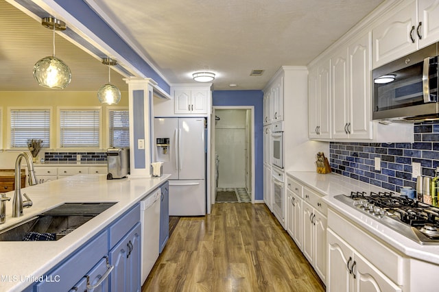 911 Newitt Vick Dr, Vicksburg, MS 39183 - kitchen featuring white appliances, a sink, white cabinetry, blue cabinets, and backsplash