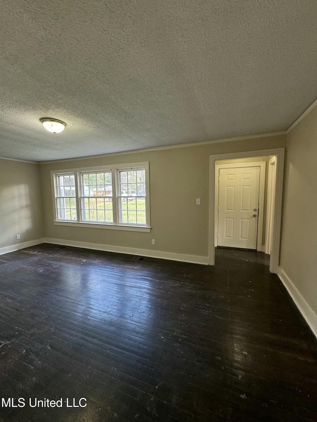 empty room featuring dark hardwood / wood-style floors, ornamental molding, and a textured ceiling