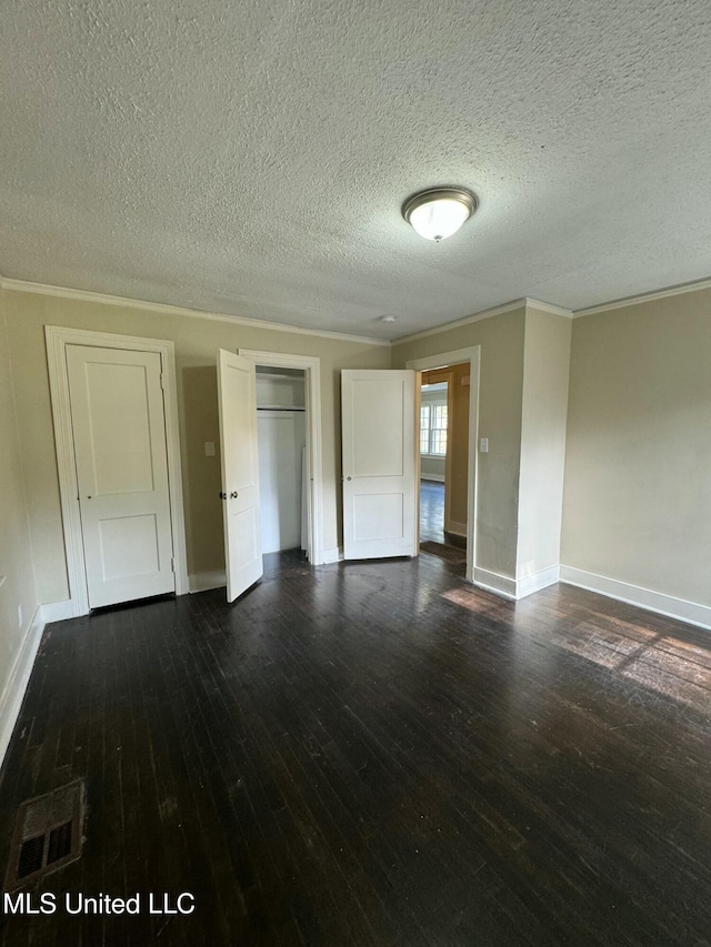 spare room featuring a textured ceiling, dark hardwood / wood-style flooring, and crown molding