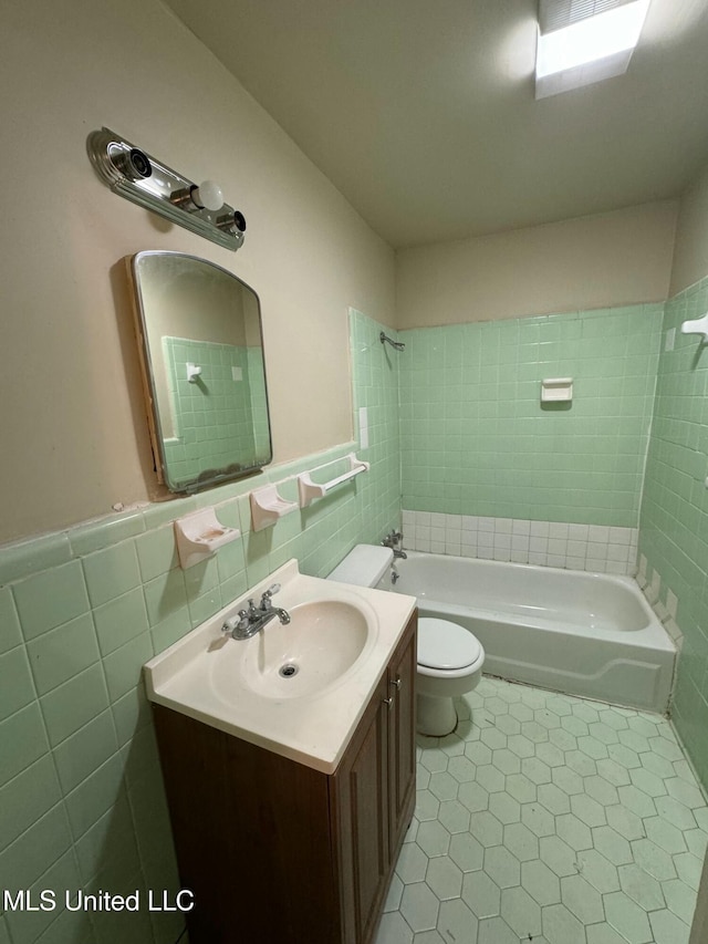 full bathroom with vanity, tile walls, and tiled shower / bath