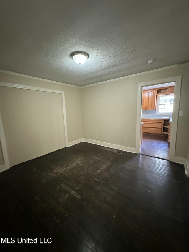 spare room featuring dark hardwood / wood-style flooring and a textured ceiling