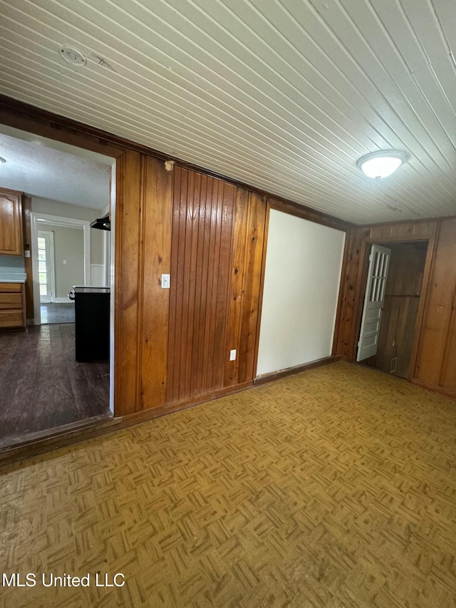 empty room with parquet floors and wood walls