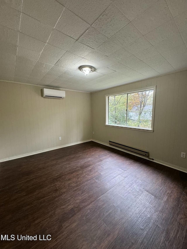 empty room with a baseboard heating unit, an AC wall unit, dark wood-type flooring, and wood walls