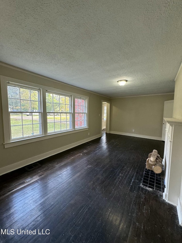 unfurnished living room featuring a textured ceiling, dark hardwood / wood-style floors, and ornamental molding