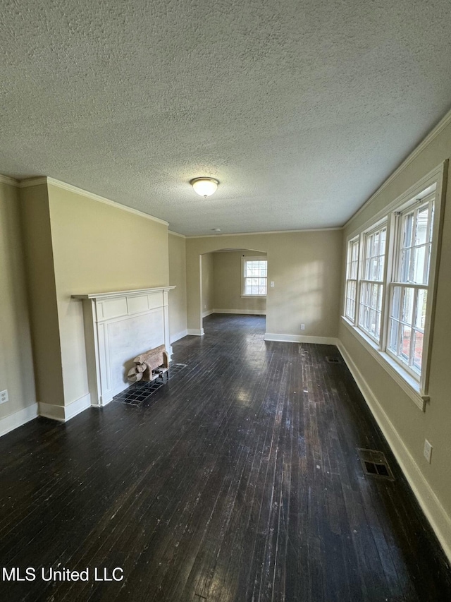 unfurnished living room featuring dark hardwood / wood-style flooring, a textured ceiling, and ornamental molding