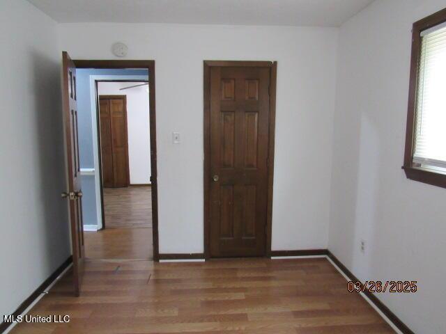 empty room featuring baseboards and wood finished floors
