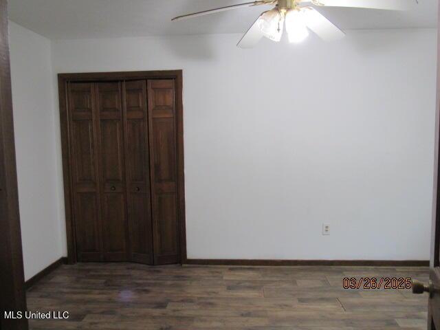 unfurnished bedroom featuring baseboards, wood finished floors, and ceiling fan