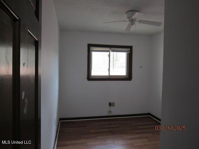 unfurnished bedroom featuring baseboards, wood finished floors, and ceiling fan