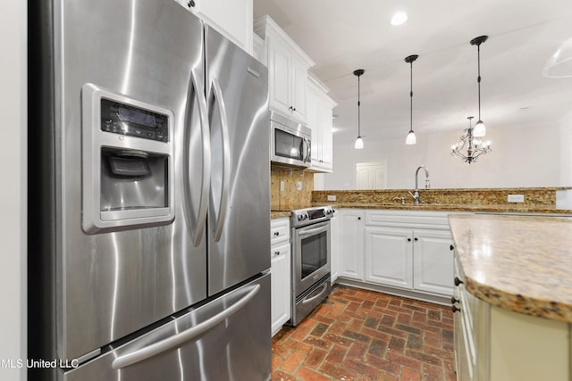 11541 Briarstone Pl, Gulfport, MS 39503 - kitchen with appliances with stainless steel finishes, brick floors, tasteful backsplash, decorative light fixtures, and white cabinetry