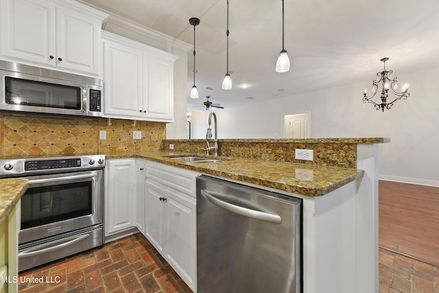11541 Briarstone Pl, Gulfport, MS 39503 - kitchen featuring stainless steel appliances, a peninsula, brick floors, tasteful backsplash, and ornamental molding