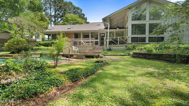 555 Rusk Dr, Brandon, MS 39047 - rear view of house featuring a sunroom, a wooden deck, a lawn, and an outdoor pool