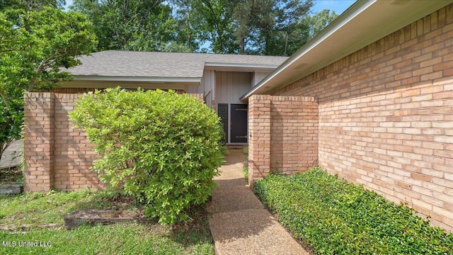 555 Rusk Dr, Brandon, MS 39047 - view of exterior entry featuring brick siding, roof with shingles, and board and batten siding