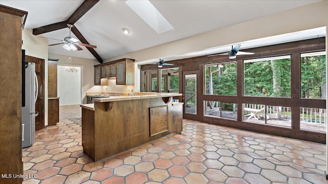 555 Rusk Dr, Brandon, MS 39047 - kitchen featuring freestanding refrigerator, a ceiling fan, a skylight, a peninsula, and a breakfast bar area