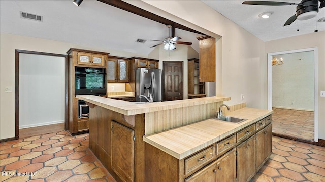 555 Rusk Dr, Brandon, MS 39047 - kitchen with stainless steel fridge with ice dispenser, black oven, ceiling fan, light countertops, and vaulted ceiling