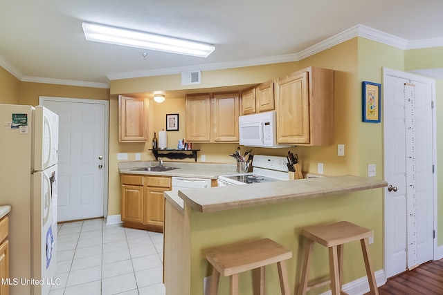 515 Third St Unit 5A, Bay Saint Louis, MS 39520 - kitchen featuring crown molding, a sink, white appliances, a kitchen bar, and visible vents