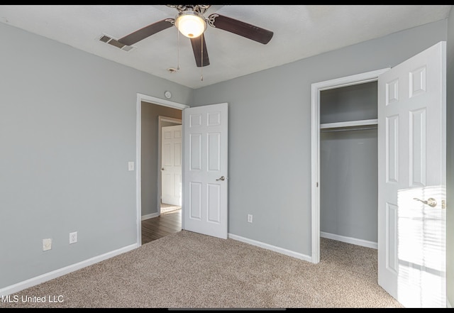 unfurnished bedroom featuring ceiling fan, a closet, and carpet flooring