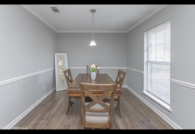 dining room with dark wood-type flooring and ornamental molding