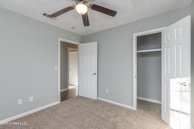 unfurnished bedroom with ceiling fan, a closet, and carpet flooring