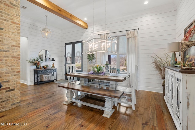 dining space with a chandelier, beam ceiling, wood-type flooring, and french doors