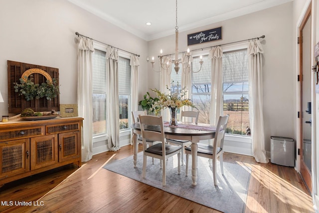 dining area with ornamental molding, wood finished floors, recessed lighting, an inviting chandelier, and baseboards