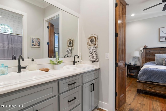 full bath with a sink, ceiling fan, double vanity, and hardwood / wood-style flooring