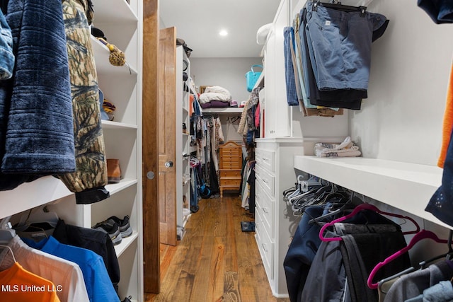 walk in closet with wood finished floors