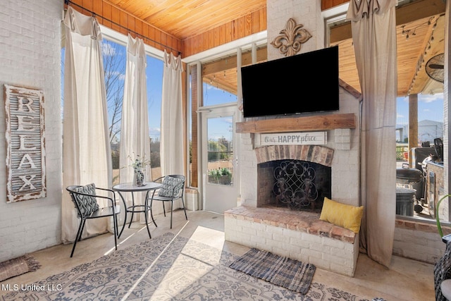 interior space with wood ceiling and an outdoor brick fireplace