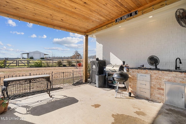 view of patio / terrace with a grill, exterior kitchen, and fence