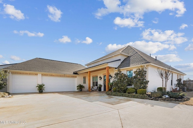 view of front of house featuring driveway, a garage, and roof with shingles