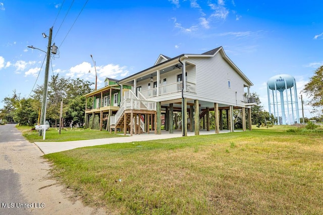 rear view of house featuring a lawn, covered porch, and a carport