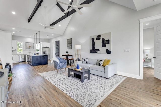 living room with light hardwood / wood-style flooring, high vaulted ceiling, and ceiling fan