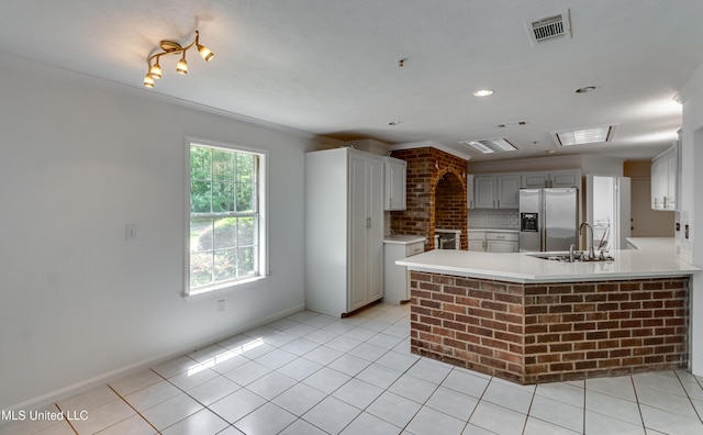 354 Lakeway Dr, Brandon, MS 39047 - kitchen with stainless steel fridge with ice dispenser, a sink, light countertops, crown molding, and light tile patterned floors