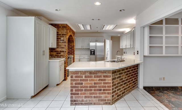 354 Lakeway Dr, Brandon, MS 39047 - kitchen with stainless steel fridge, a sink, a peninsula, tasteful backsplash, and recessed lighting