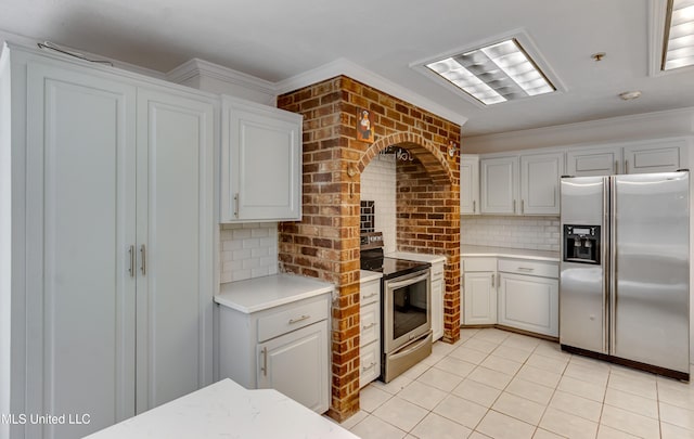 354 Lakeway Dr, Brandon, MS 39047 - kitchen featuring stainless steel appliances, light countertops, decorative backsplash, light tile patterned floors, and ornamental molding