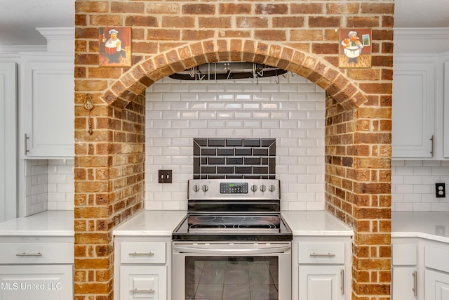 354 Lakeway Dr, Brandon, MS 39047 - kitchen featuring stainless steel range with electric cooktop, tasteful backsplash, light countertops, ornamental molding, and white cabinetry