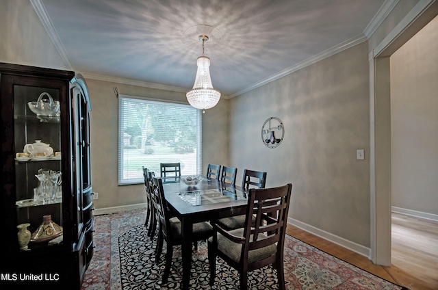 dining space with ornamental molding, hardwood / wood-style flooring, and a chandelier