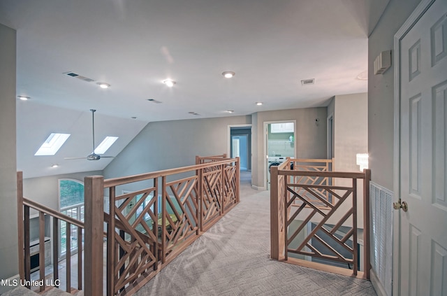 hallway featuring light carpet and lofted ceiling with skylight