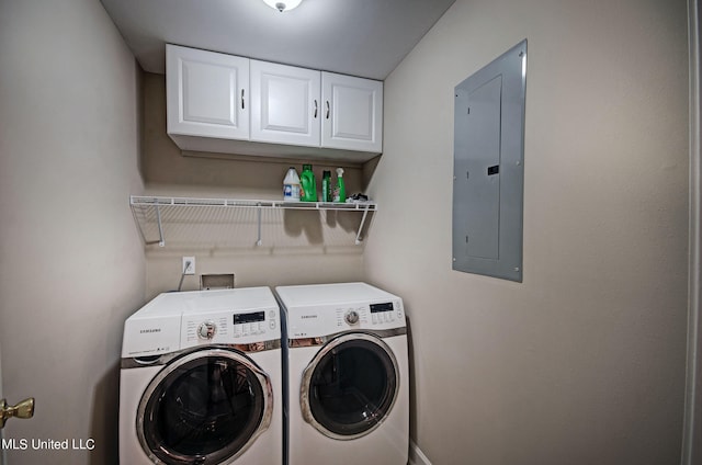 laundry room with electric panel, washing machine and clothes dryer, and cabinets