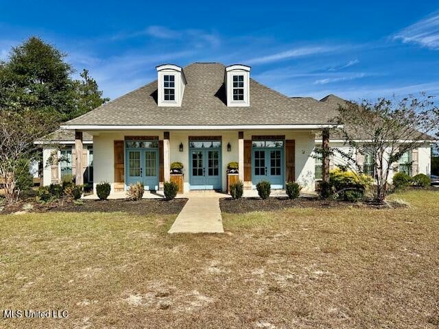 view of front of property with a front yard and french doors