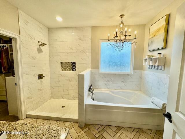 bathroom with independent shower and bath and an inviting chandelier