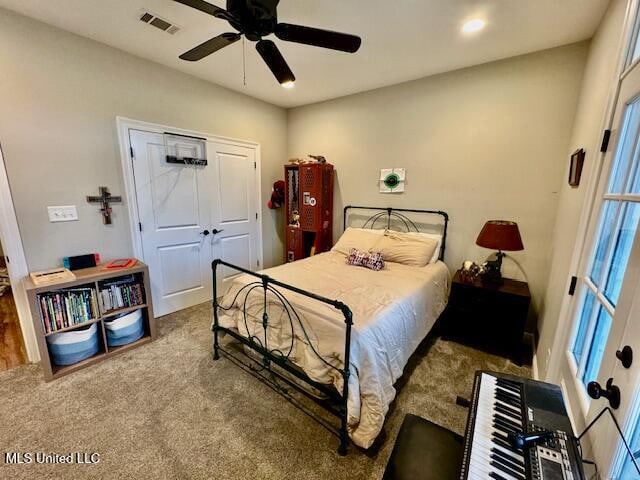 carpeted bedroom featuring a closet, ceiling fan, and multiple windows