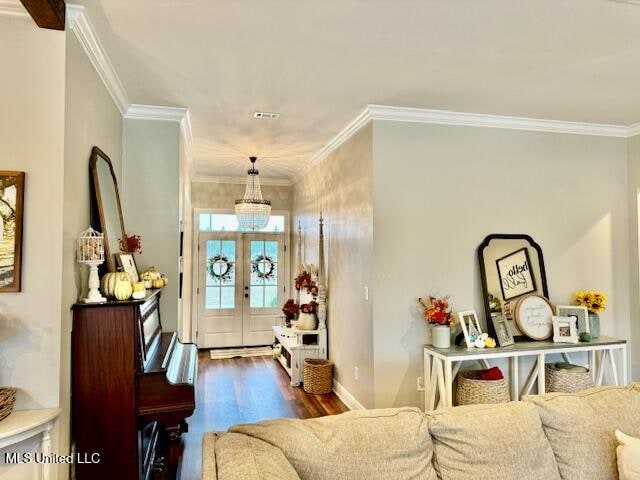 foyer entrance with dark wood-type flooring, crown molding, and french doors