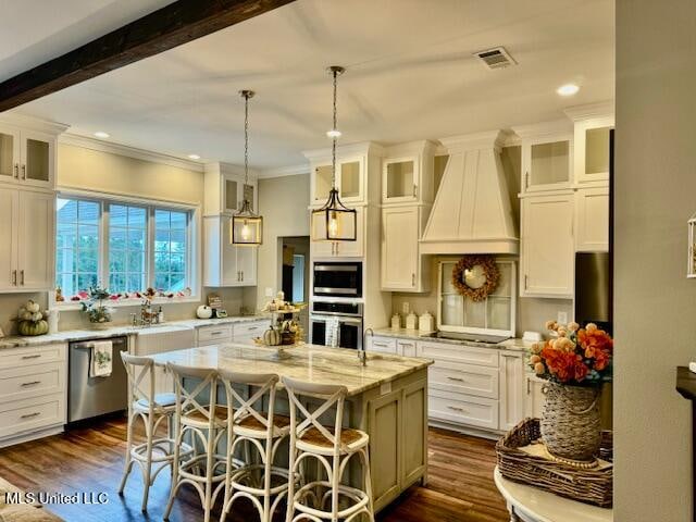 kitchen featuring a center island, a kitchen bar, pendant lighting, custom exhaust hood, and appliances with stainless steel finishes