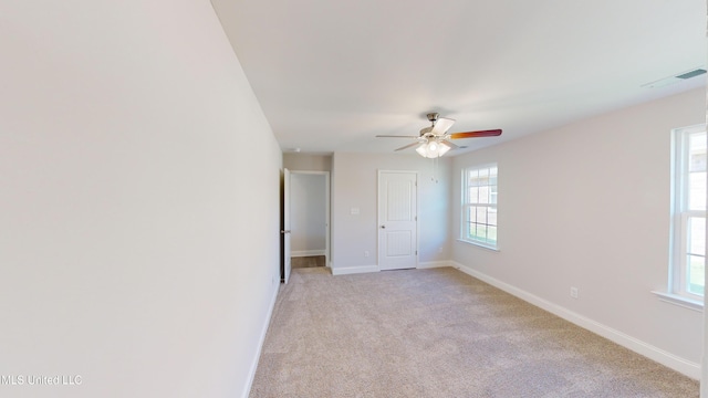 unfurnished bedroom featuring ceiling fan, light carpet, and multiple windows