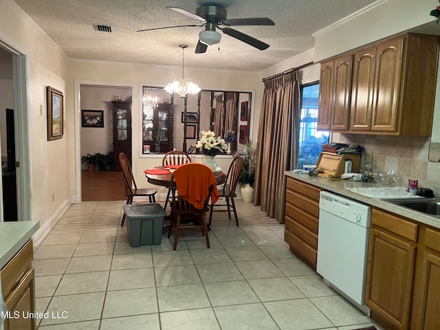 kitchen with white dishwasher, ornamental molding, decorative light fixtures, light tile patterned floors, and tasteful backsplash