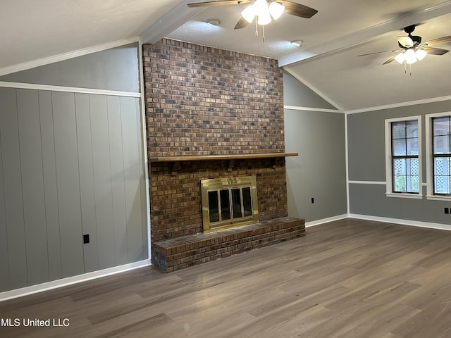 unfurnished living room with vaulted ceiling with beams, hardwood / wood-style flooring, a fireplace, and ornamental molding