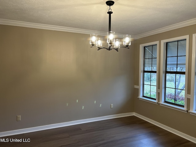 spare room featuring a notable chandelier, dark hardwood / wood-style flooring, ornamental molding, and a textured ceiling