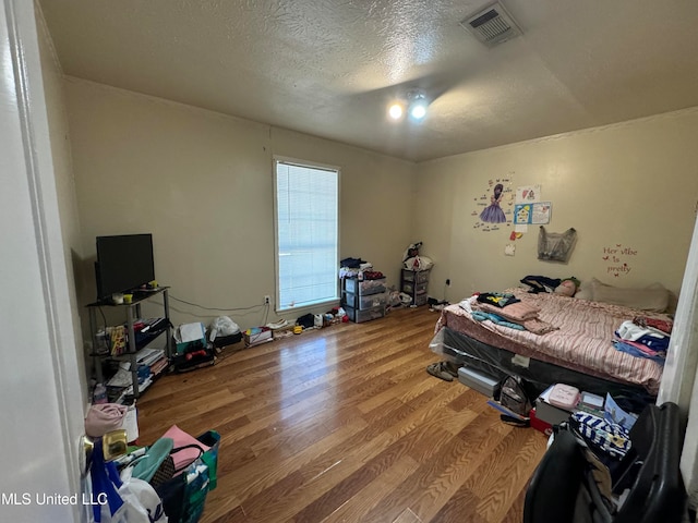 bedroom featuring hardwood / wood-style floors and a textured ceiling