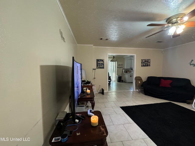 living room featuring ceiling fan, light tile patterned flooring, a textured ceiling, and ornamental molding