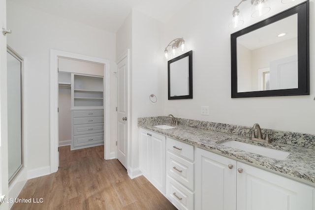 bathroom featuring vanity, hardwood / wood-style floors, and a shower with door